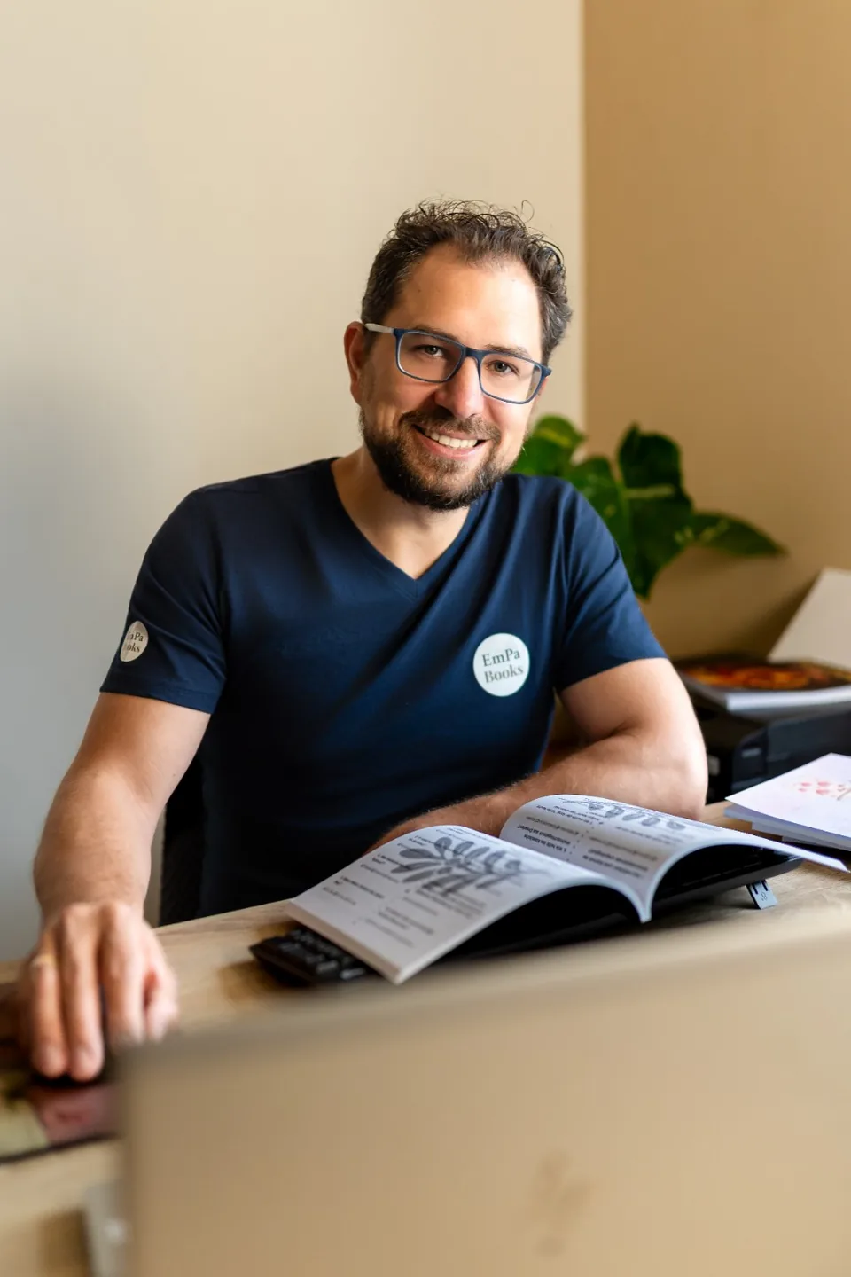 Jan von EmPa Books lächelt an seinem Schreibtisch